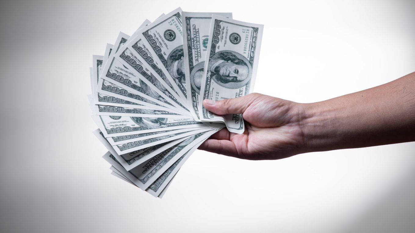 person holding 100 US Dollar banknote